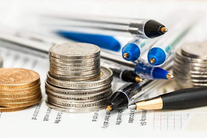 coins and pens on top of a form paper