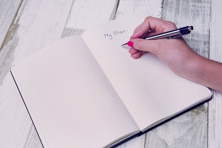 a woman writing down her plan on her book