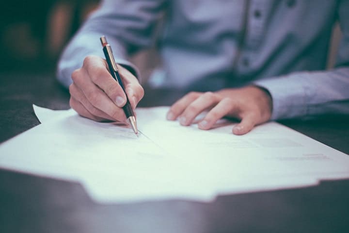 a man writing on the papers