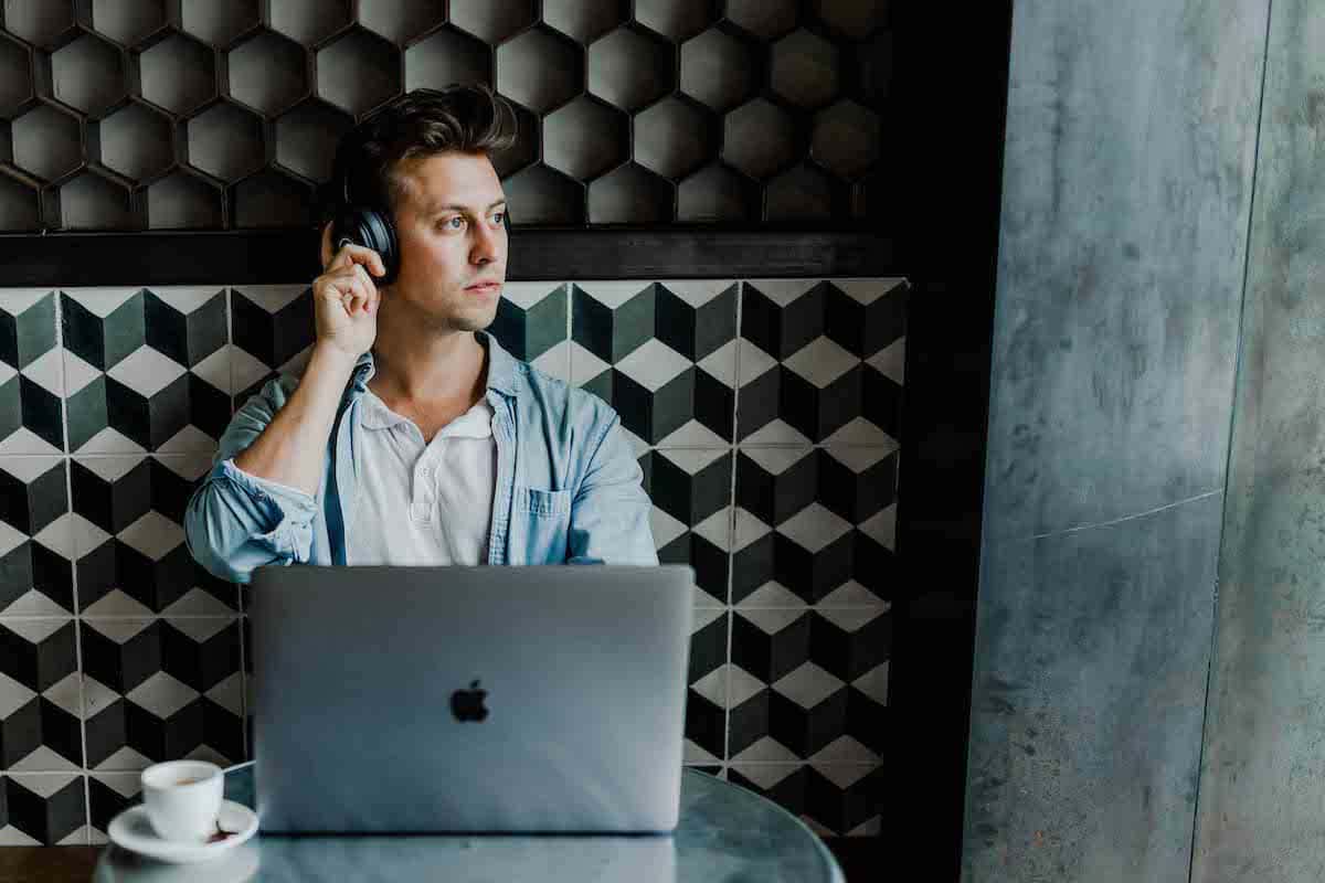 a man listening to music while working in front of a laptop