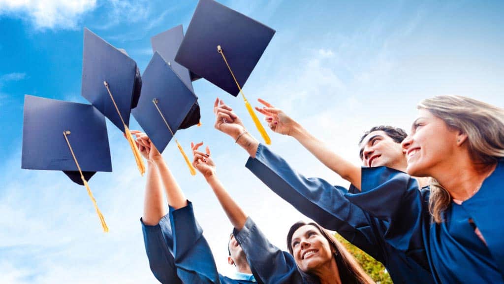 Graduating students throwing their graduation caps to the air